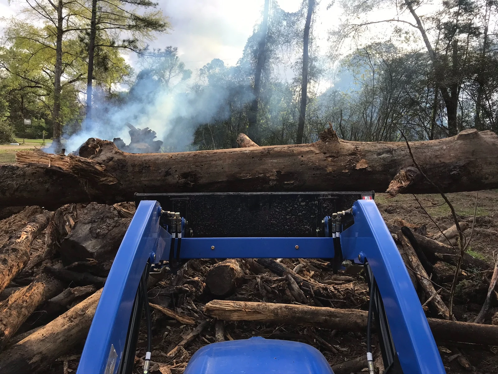 Front loader handling large logs and debris